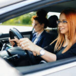 Condutora ruiva dirigindo, ilustrando direitos de motoristas iniciantes.