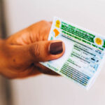 Mão segurando uma carteira de habilitação (CNH).