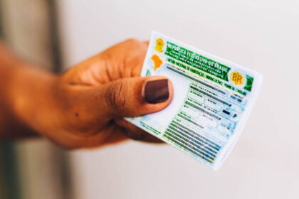 Mão segurando uma carteira de habilitação (CNH).