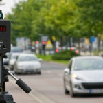 Radar móvel de fiscalização de velocidade com carros passando pela via.”
